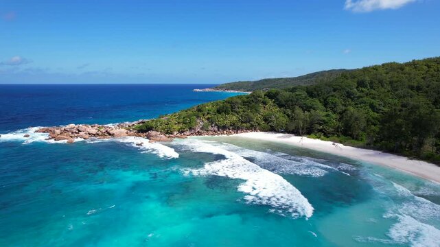 Grand Anse Beach curves along La Digue coast in Seychelles. Aerial