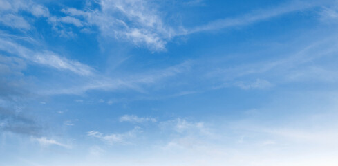 Clear blue sky with wispy clouds drifting gently © lovelyday12
