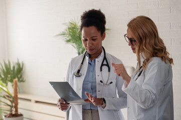 Two female doctors discussing medical imaging and sharing professional opinions during a clinical...