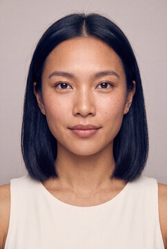 Closeup female portrait with neutral expression and clear skin for headshot profile and skincare branding use