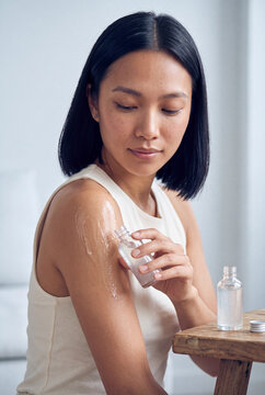 Woman applying body oil to arm for moisturizing skincare routine and body care product advertisement background
