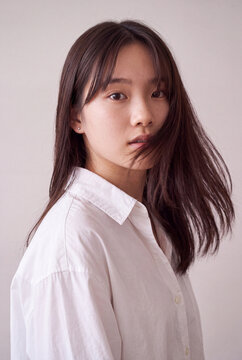 Young woman in white shirt with hair in motion for fashion portrait background and minimalist editorial composition
