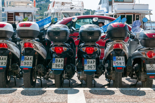  A row of parked scooters available for hire on the Greek island of Skiathos, a popular tourist destination in the Aegean Sea.