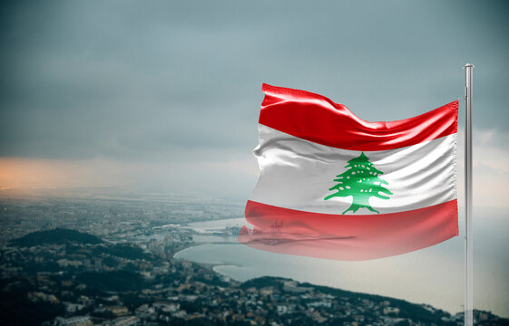 Lebanon flag waving over a coastal city under dramatic cloudy sky, realistic fabric motion, aerial seaside landscape background. Lebanon national flag for independence day.