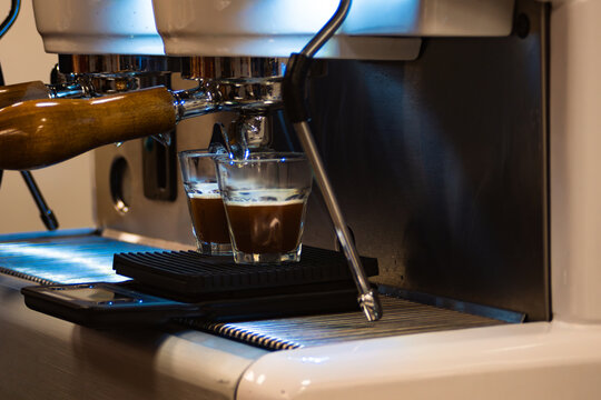 Espresso machine brewing two fresh coffee shots. Concept of aromatic flavor of freshly made coffee. Coffe International day