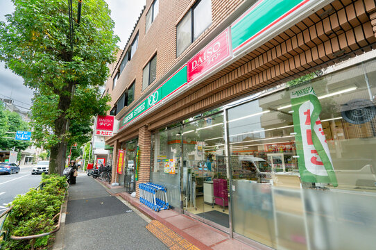 NAKANO-KU, TOKYO, JAPAN - AUGUST 30, 2026: Combined storefront of Lawson Store 100 and Daiso 100-yen shop along the street in Nakano-ku, Tokyo.