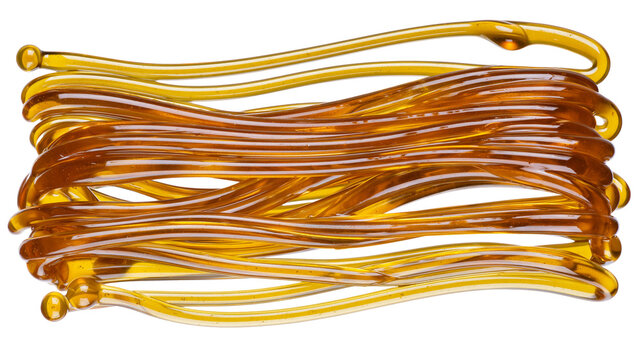 Amber colored viscous liquid strands, isolated on transparent background