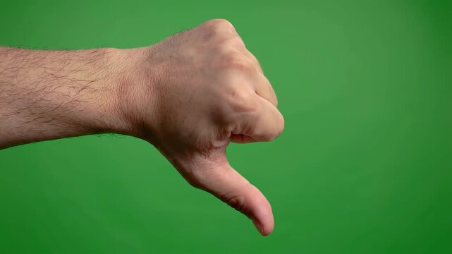Hand gesture thumbs down on green screen background.