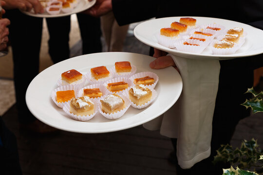 Waiter carrying plates of bite-sized appetizers during restaurant service