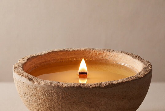 Molten Organic Soy Wax Pool Reflecting Candlelight In Sandstone Vessel