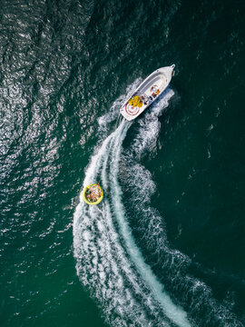Aerial View of Speedboat Towing Inflatable Tube on Deep Blue Sea