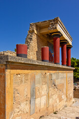 Naklejka premium A reconstructed section of the Palace of Knossos on Crete, Greece, featuring the characteristic red Minoan columns, decorated architectural elements and a colorful bull fresco.