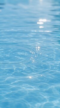Clear blue water with gentle ripples reflecting sunlight, creating sparkles on the surface.