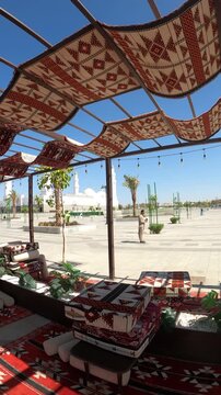 View of historic Masjid Quba from a traditional outdoor Arabic seating area.