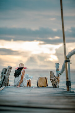 Woman tourist in happiness and relax moment on wooden pier, enjoy the summer trip in tropical island