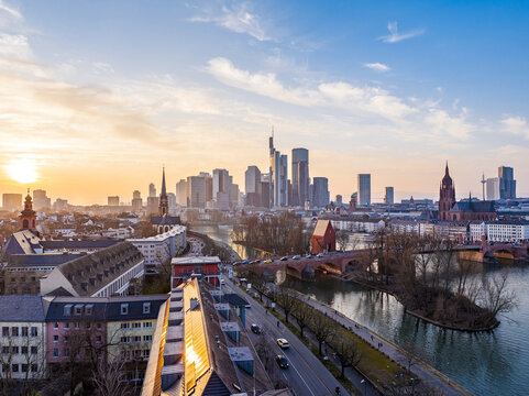 Aerial view of Dreikonigskirche and the Frankfurt skyline along the Main river at sunset with modern skyscrapers and historic architecture in Frankfurt am Main, Hessen, Germany.