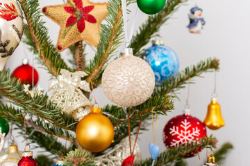 Naklejka premium A Christmas tree stands with many colorful ornaments hanging from its branches. Each ornament shows different shapes and colors, celebrating the festive season and bringing joy to the home