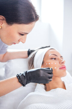 Female skincare specialist applying treatment on a woman face in a bright spa setting, showcasing beauty care techniques and professional skincare practices
