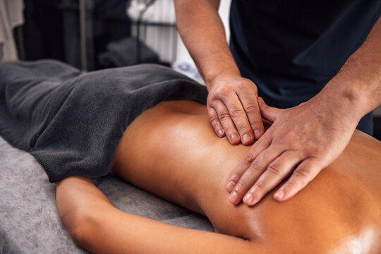 Asian woman receiving a professional massage in a serene spa environment, with soft lighting and calming decor, promoting relaxation and wellness through therapeutic touch