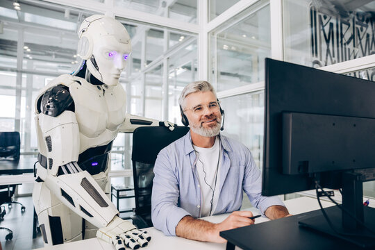 Businessman and robot collaborating in modern office working together on workplace