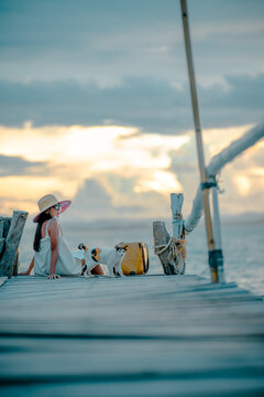 Woman tourist in happiness and relax moment on wooden pier, enjoy the summer trip in tropical island