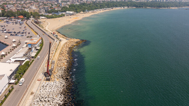 Aerial view of breakwater construction. Crane puts tetrapods on breakwater construction
