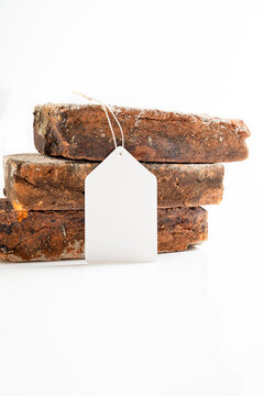 Three stacked rustic, weathered bricks on a white background with a blank white tag. Mockup or Copyspace