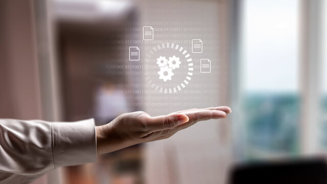 Business person holding a digital hologram of gears and document icons. Concept of cloud computing storage and digital storage technology