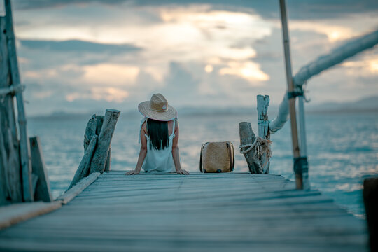 Woman tourist in happiness and relax moment on wooden pier, enjoy the summer trip in tropical island
