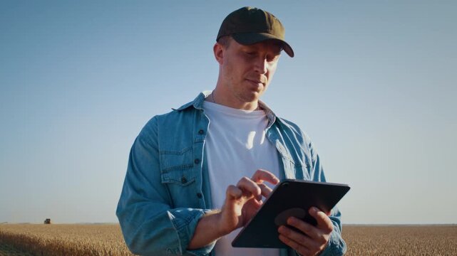 Farmer maintains automation with digital tablet in wheat field