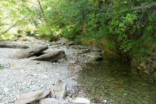 Large boulders and shallow clear water in a rocky mountain stream bed, Brent de l'Art, Italy