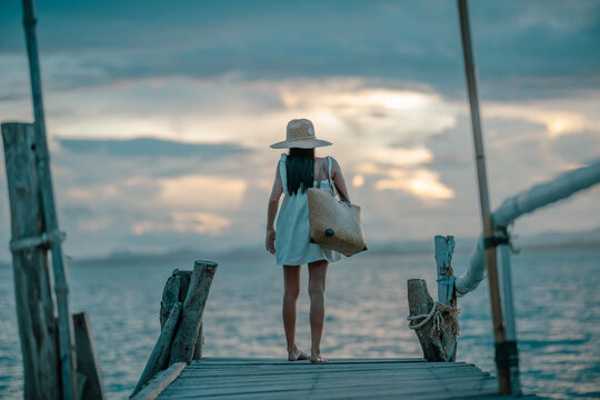 Woman tourist in happiness and relax moment on wooden pier, enjoy the summer trip in tropical island