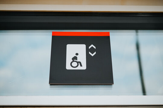 A sign is displayed above an elevator door, showing an icon of a person in a wheelchair.