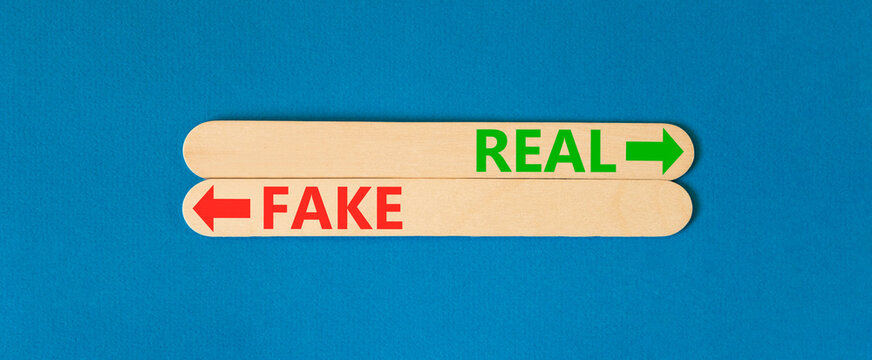 Real or fake words symbol. Concept words Fake and Real on beautiful wooden sticks. Beautiful blue background. Business and real or fake concept. Copy space.