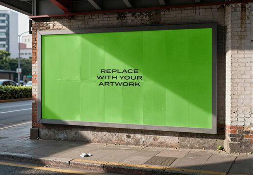 Large outdoor billboard mockup with placeholder screen mounted on a brick wall at street corner, realistic urban advertising display natural sunlight and sidewalk environment