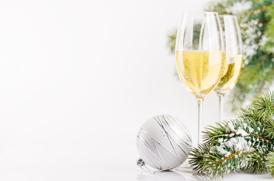 Champagne glasses and snowy fir on white