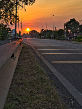 Beautiful glowing sun at the end of rural road in Alor Setar, Kedah