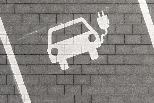 Aerial view of an electric vehicle charging symbol painted on the paved ground of the Lincolnsiedlung residential area in Darmstadt, Hessen, Germany.