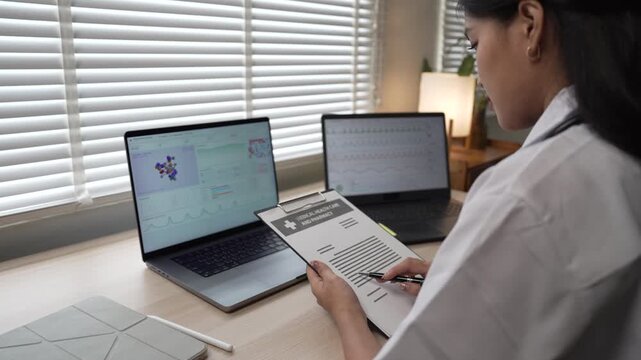 Medical researcher working with dual laptops and analyzing healthcare data in office