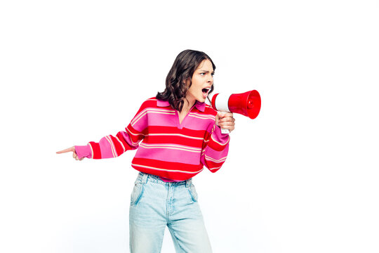 Woman shouting into megaphone while pointing, energetic protest announcement and communication concept