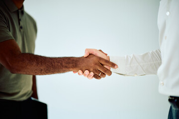 Two diverse business partners shaking hands, symbolizing agreement, partnership, collaboration, and trust in a professional setting © we.bond.creations