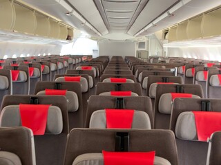 Fototapeta premium Empty airplane cabin interior showing rows of seats and overhead compartments