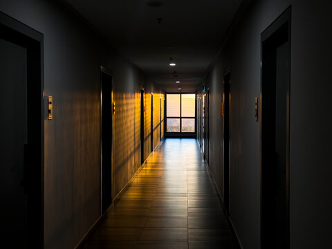 Hotel corridor leading to open window with sunlight