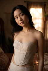 Fototapeta premium Young Asian woman wearing linen corset in warm natural light