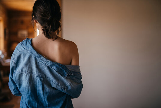Young Asian woman wearing denim shirt, rear view portrait