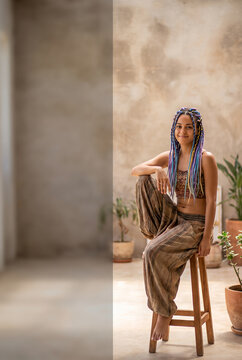 Young Black woman with blue braids sitting on wooden stool in minimalist courtyard