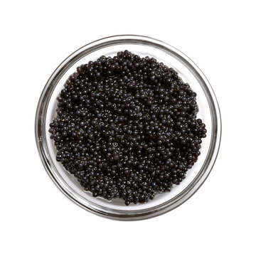 Black caviar made from lumpfish roe, in a glass bowl, isolated from above. Affordable, small, deep black dyed, salted fish eggs from Cyclopterus lumpus, also called lumpsucker, used as garnish. Photo