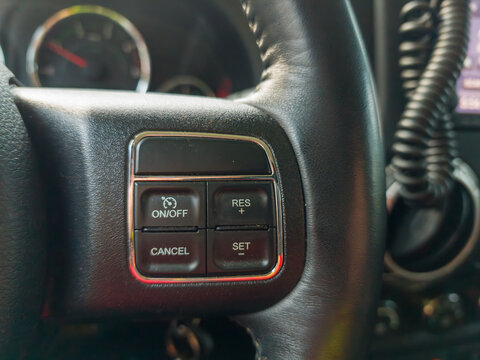 Close up of cruise control steering wheel buttons in a modern car