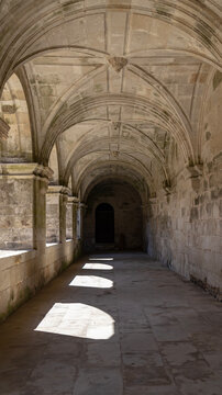 Stone cloister hallway with arches and game of light and shadows