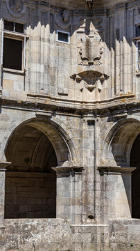 Architectural detail of heraldic shield and arches in granite cloister